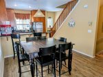 Large dining table with seating for 6, plus 2 stools at the breakfast bar